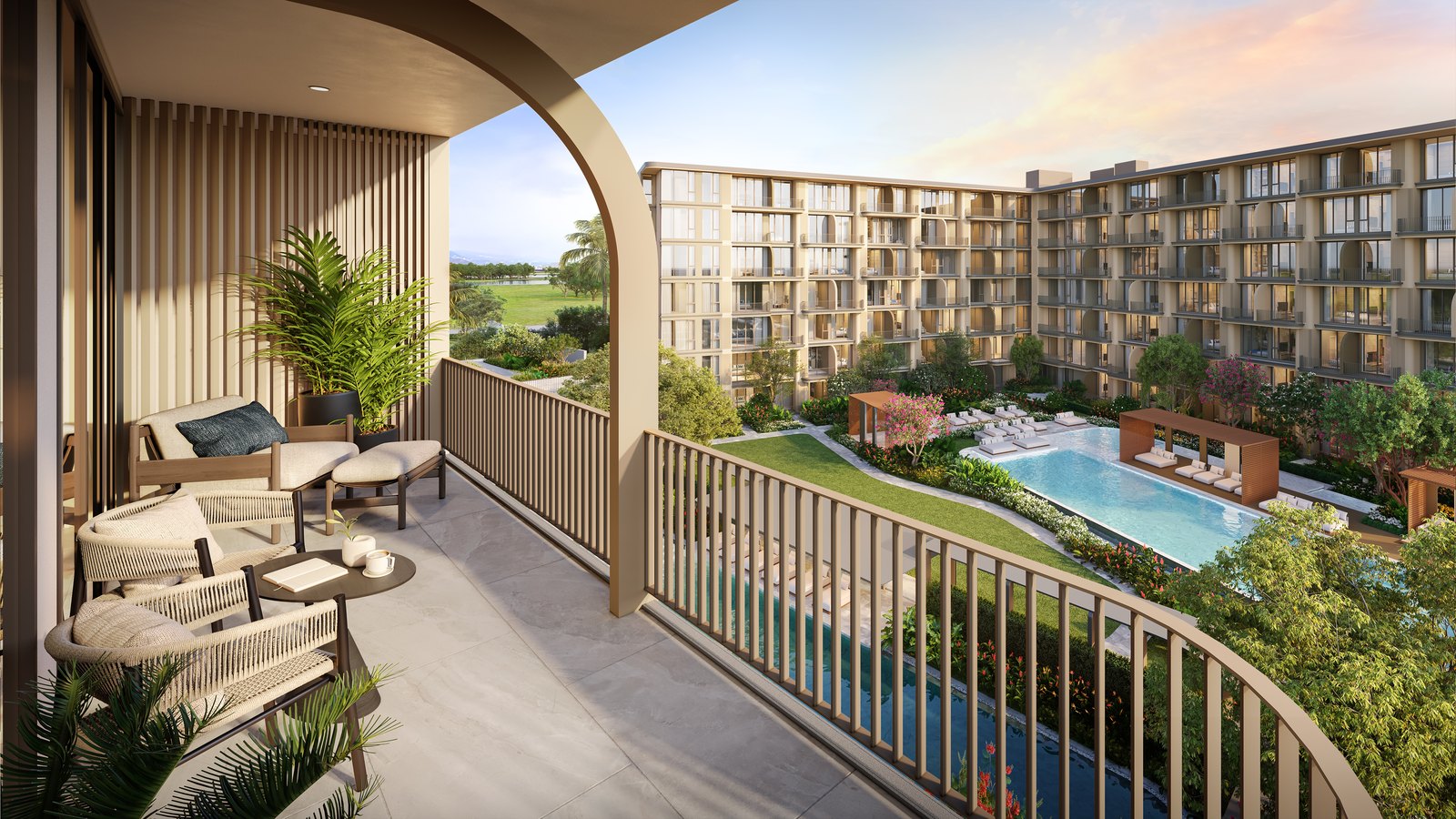 A balcony with armchairs overlooking the courtyard pool