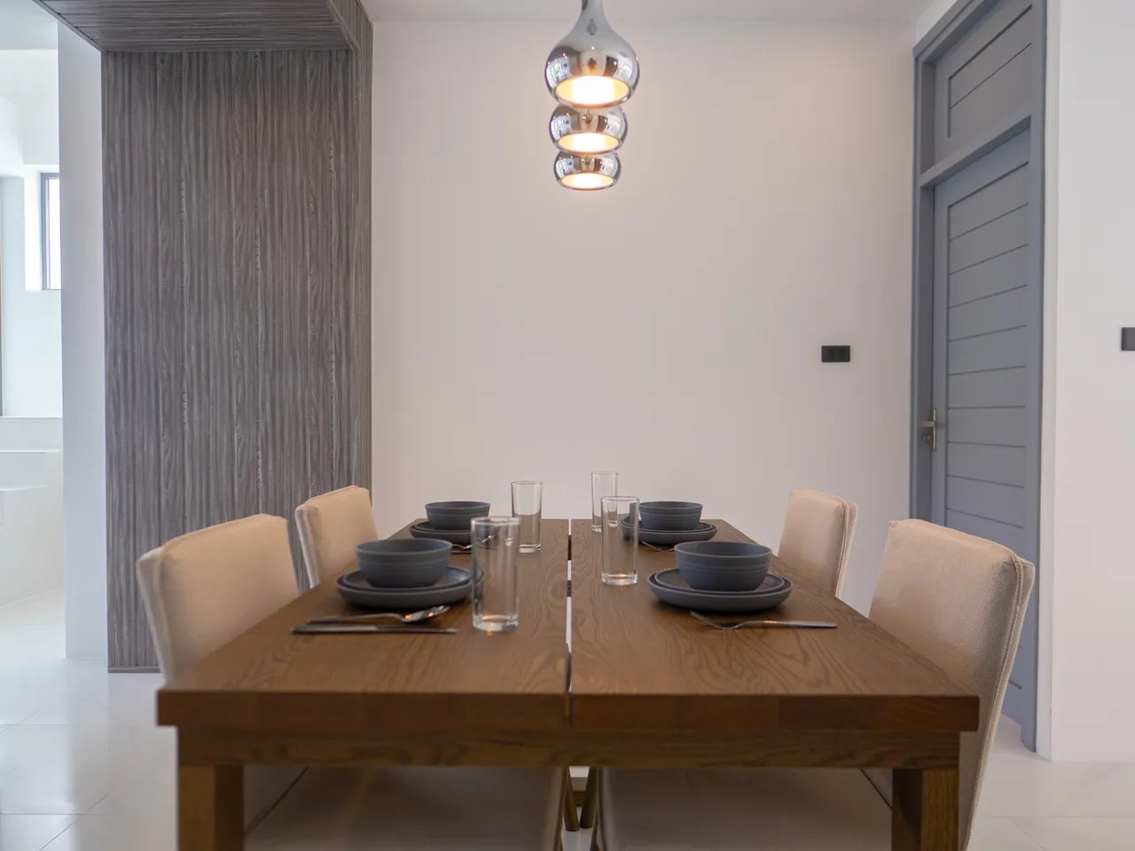 The dining table with the kitchen behind it