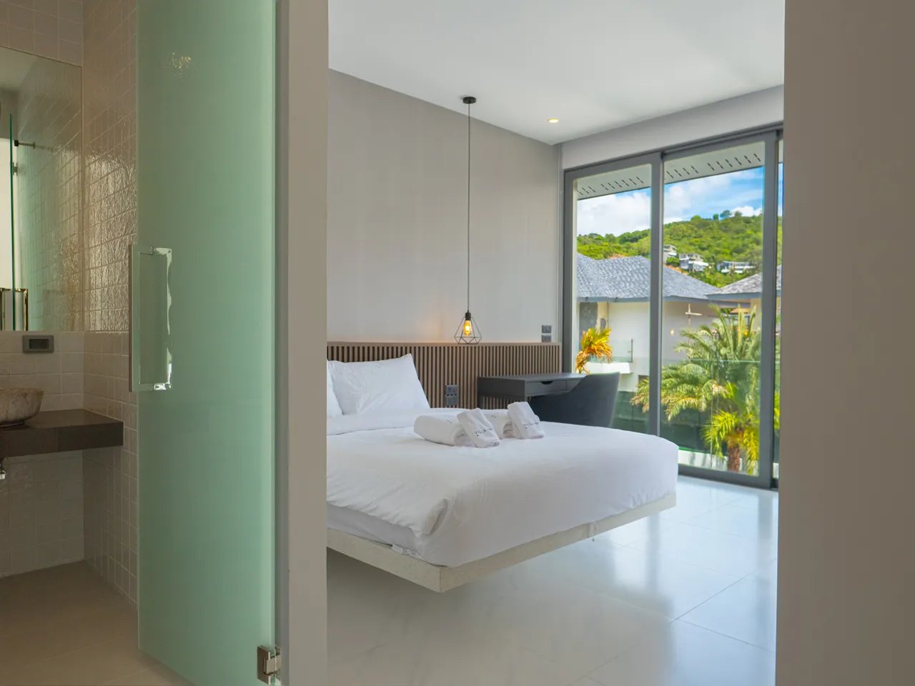 A bedroom with its bathroom behind the glass door