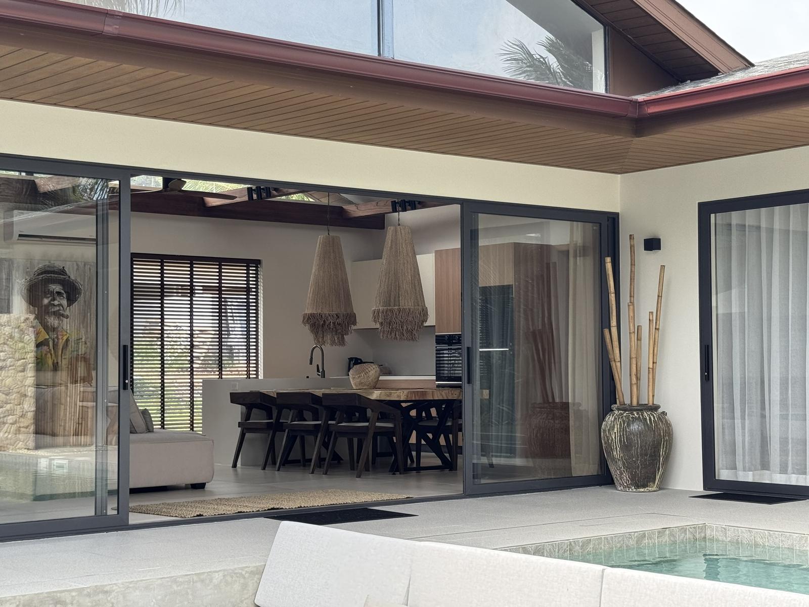 The villa from the pool terrace, doors open to the living room