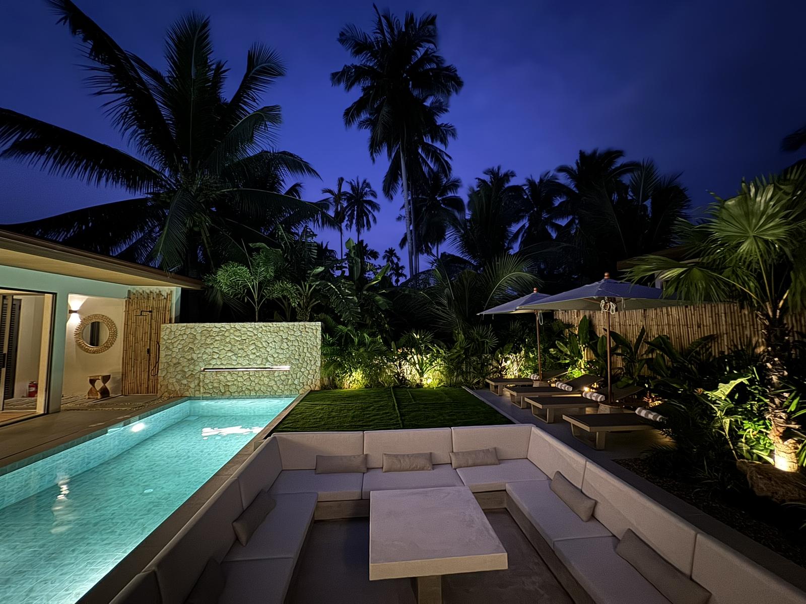 The pool and garden lit at dusk