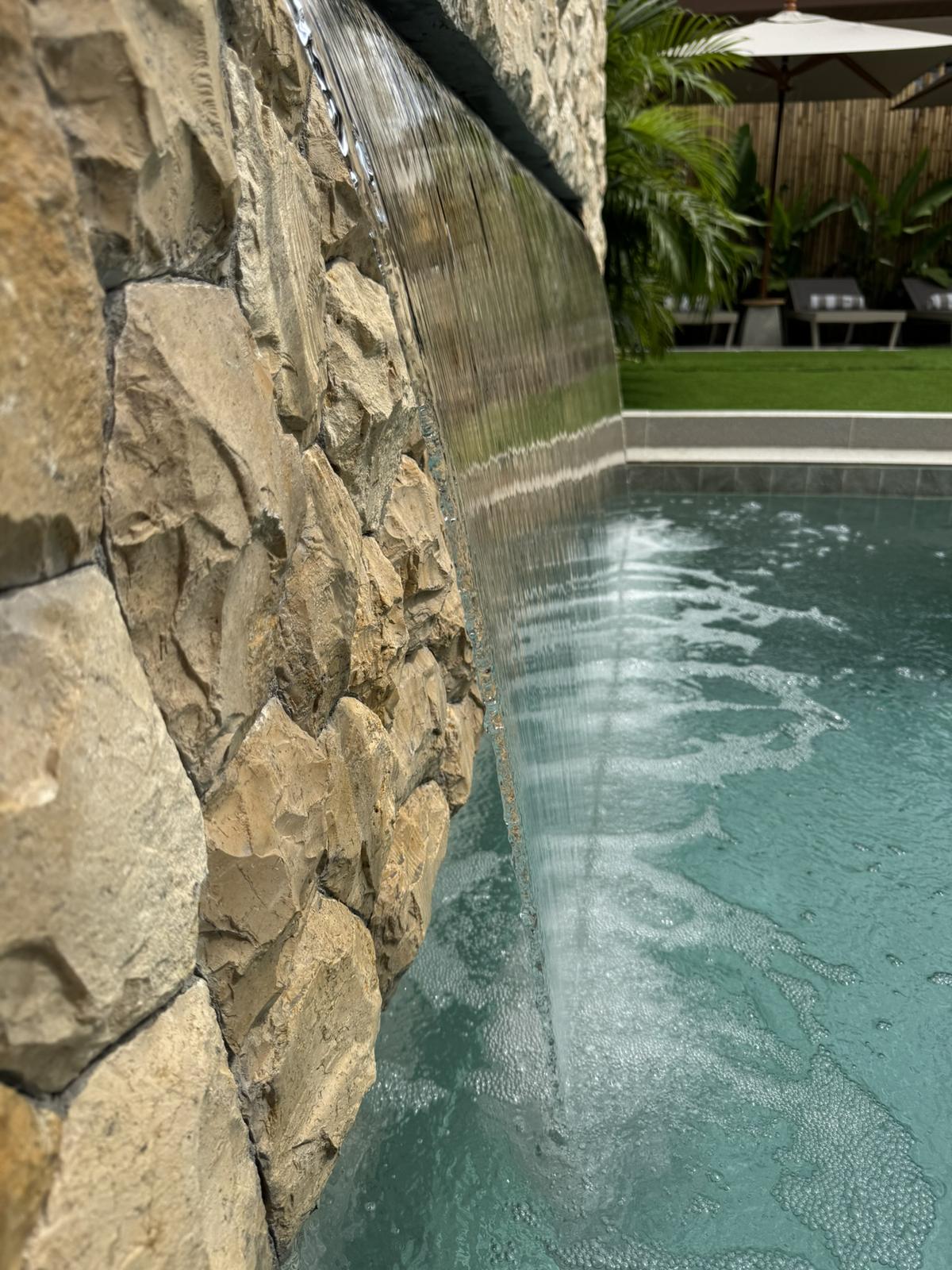 Water feature running down the stone garden wall