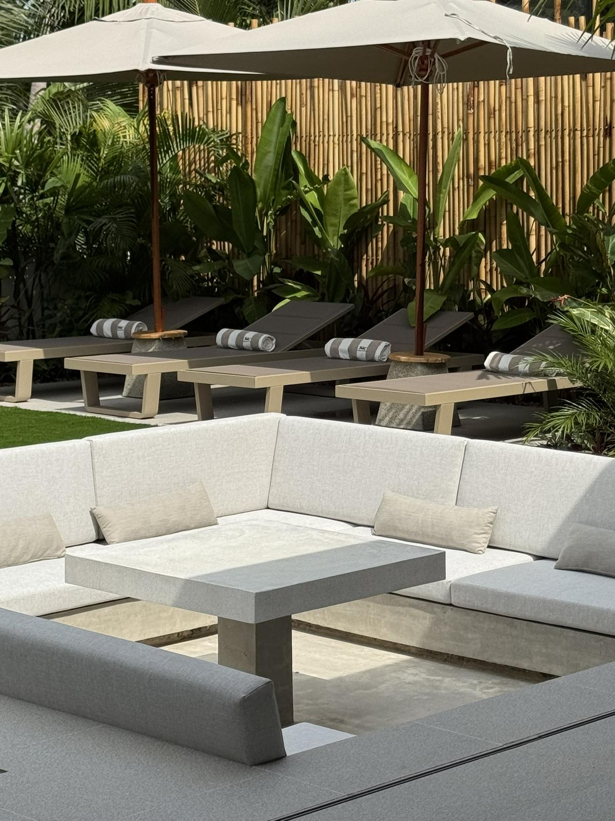 Loungers and a low stone table by the water