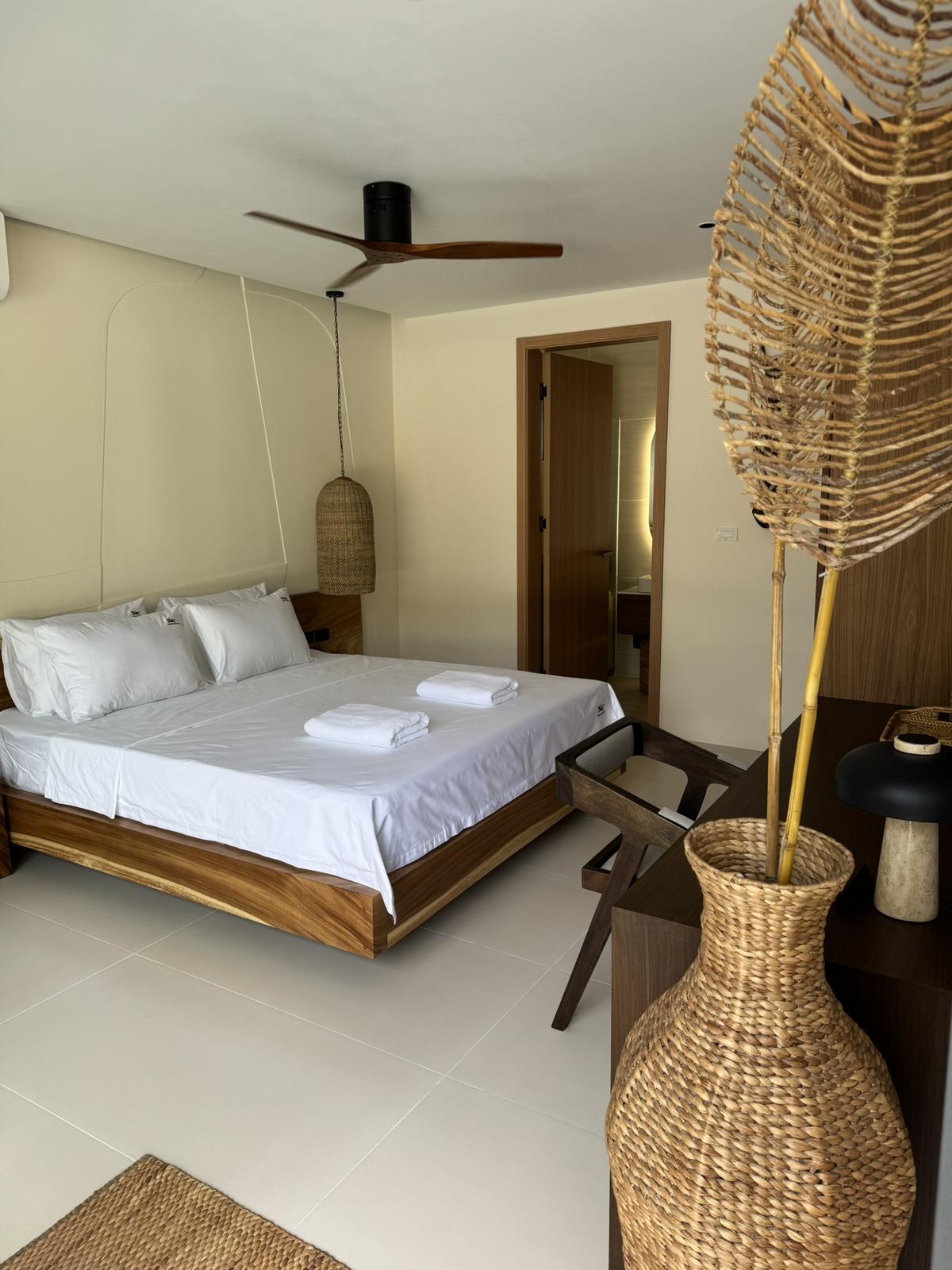 Bedroom furnished in solid wood with an en-suite beyond