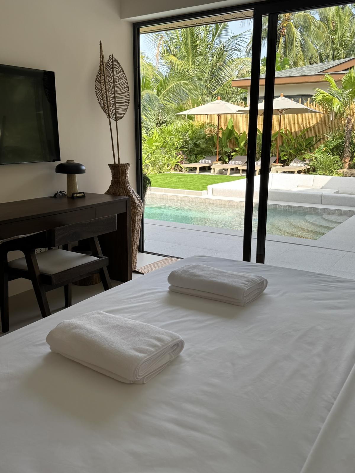 Bedroom with a desk and sliding glass onto the pool