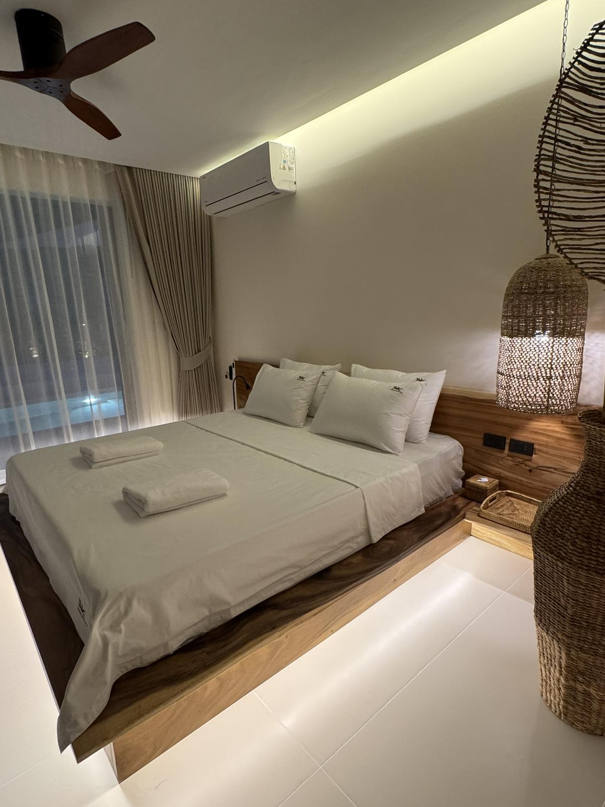 Bedroom with soft cove lighting and woven details