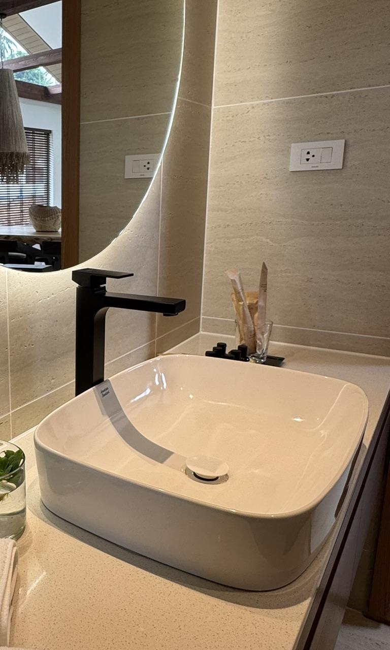 Bathroom with a stone vanity and backlit round mirror