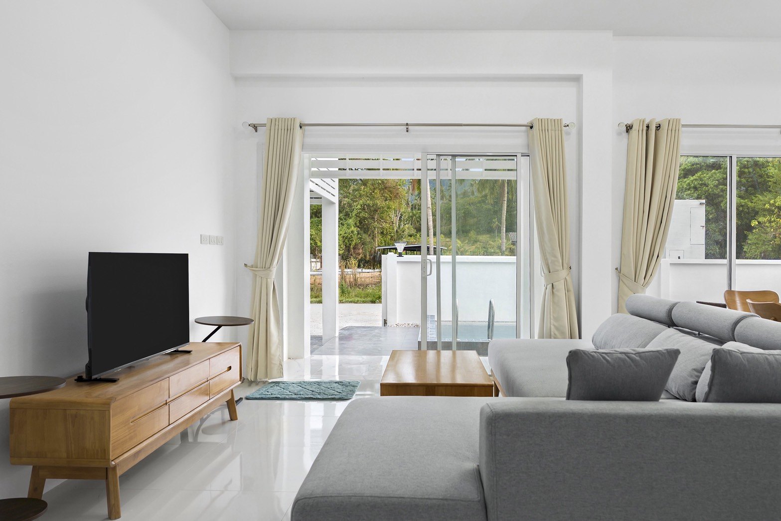Living room with sliding doors open to the pool terrace