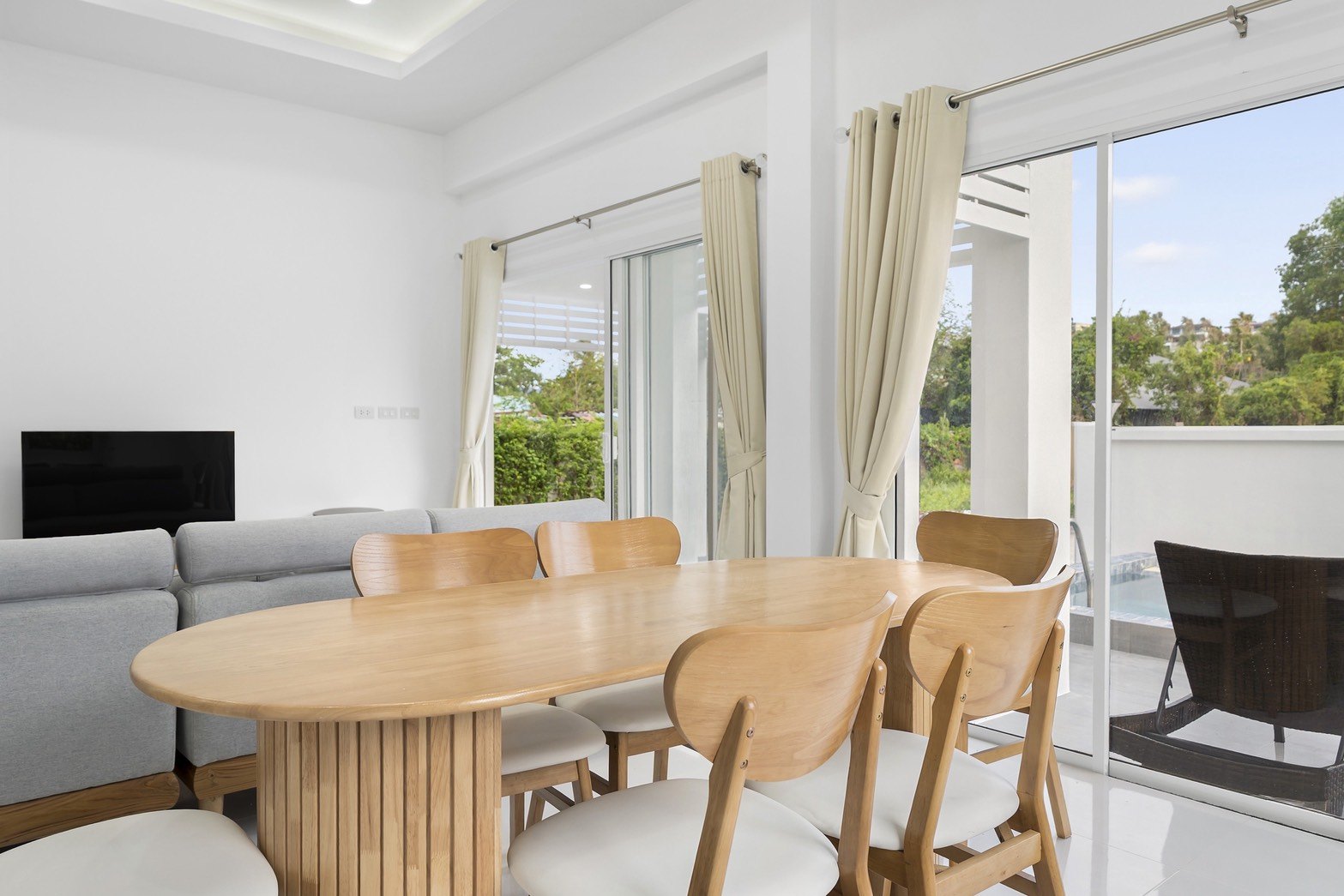Dining table beside the living room, garden views on two sides