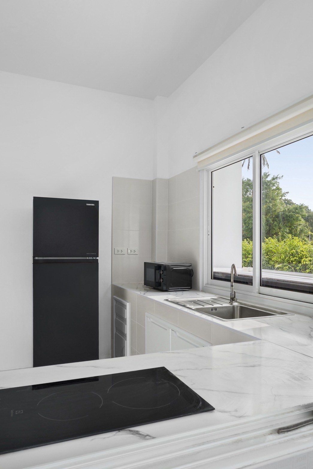 Fitted kitchen with hob, sink and full-height fridge