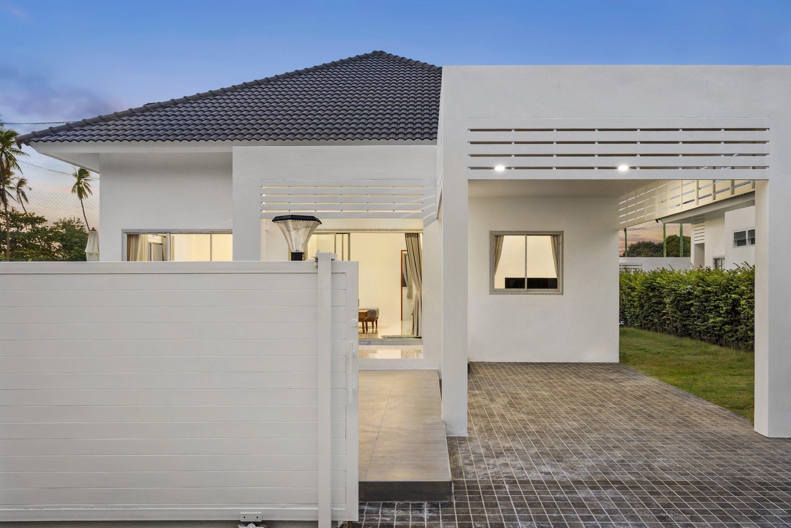 Entrance and paved parking in front of a villa