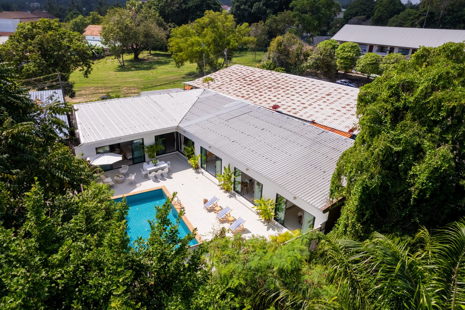 The villa from above, a single storey wrapped around the pool on its garden plot