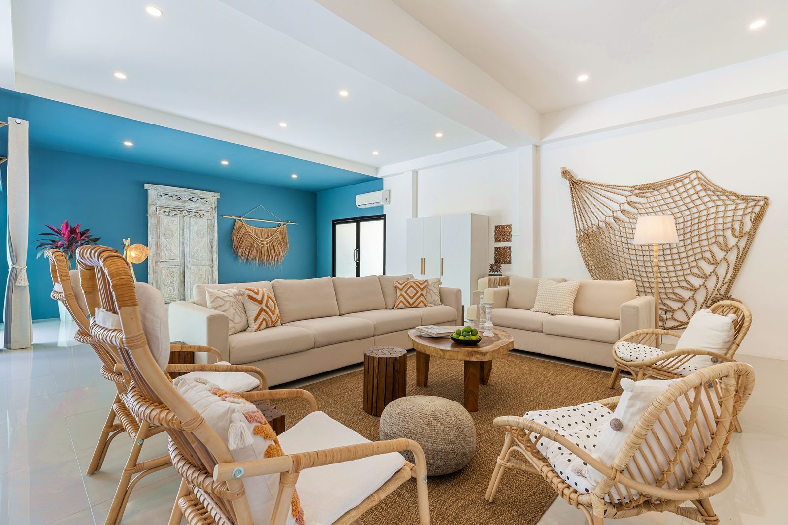 Lounge with a teal feature wall and rattan seating
