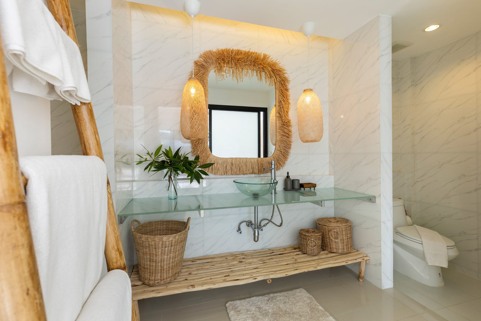 Bathroom with a rattan-framed mirror and glass basin