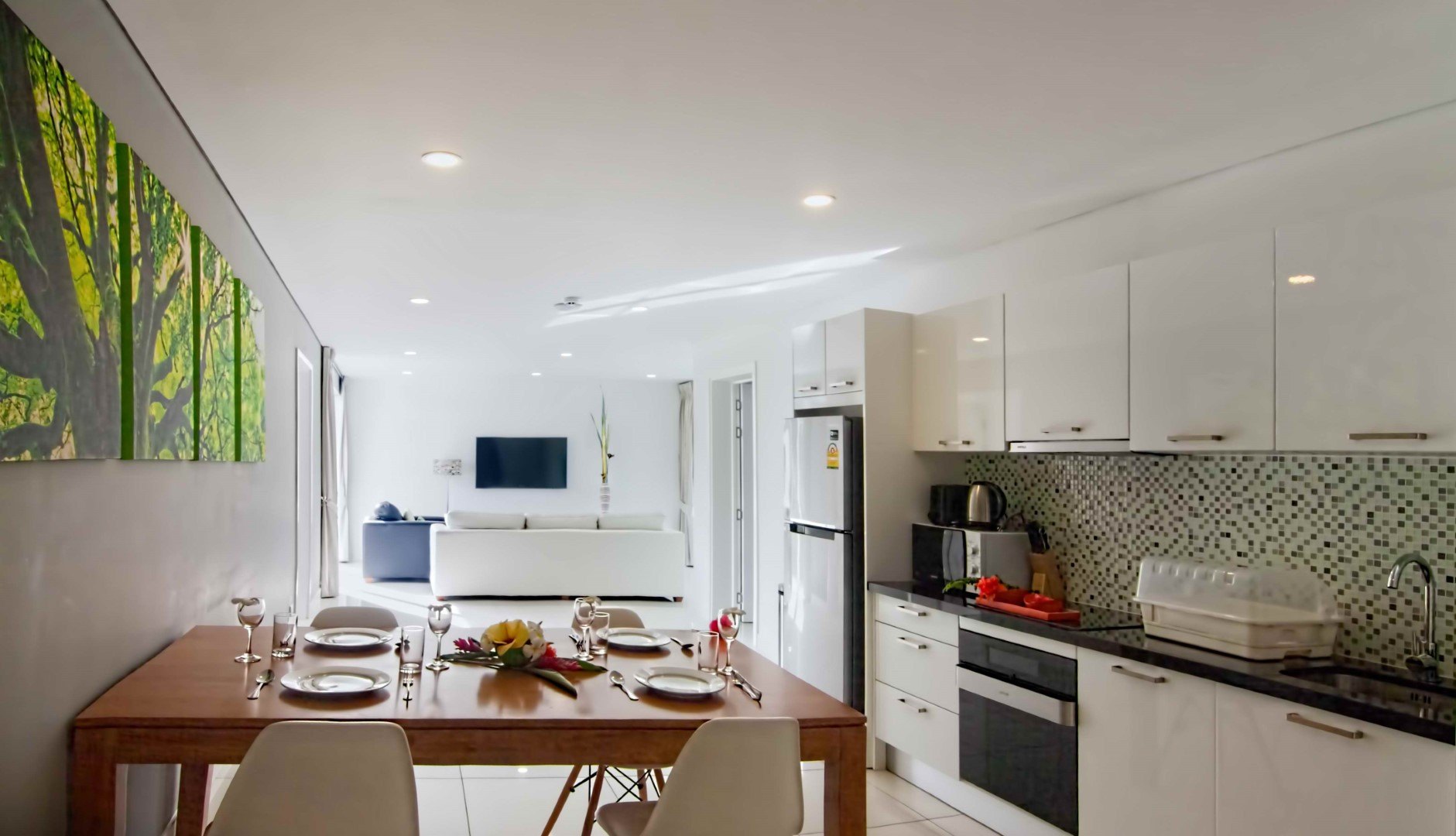 The dining table and the fitted kitchen behind it