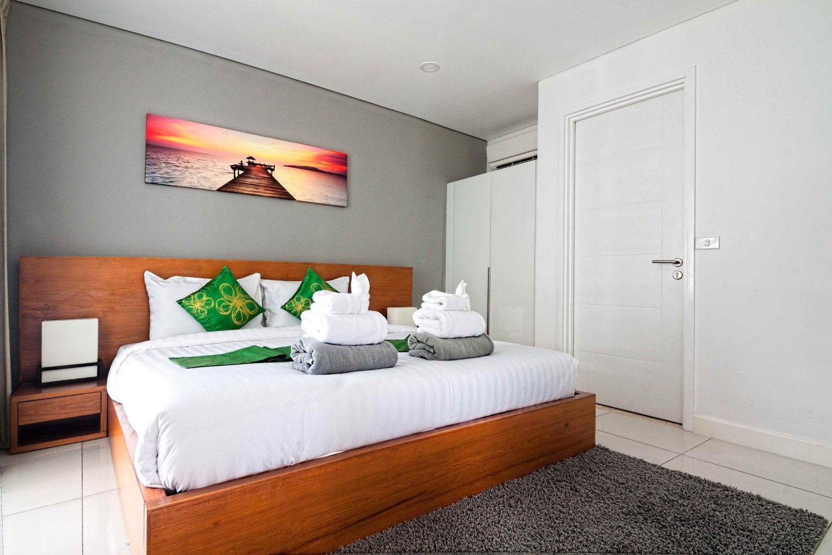 A bedroom with wardrobes and a wall of storage