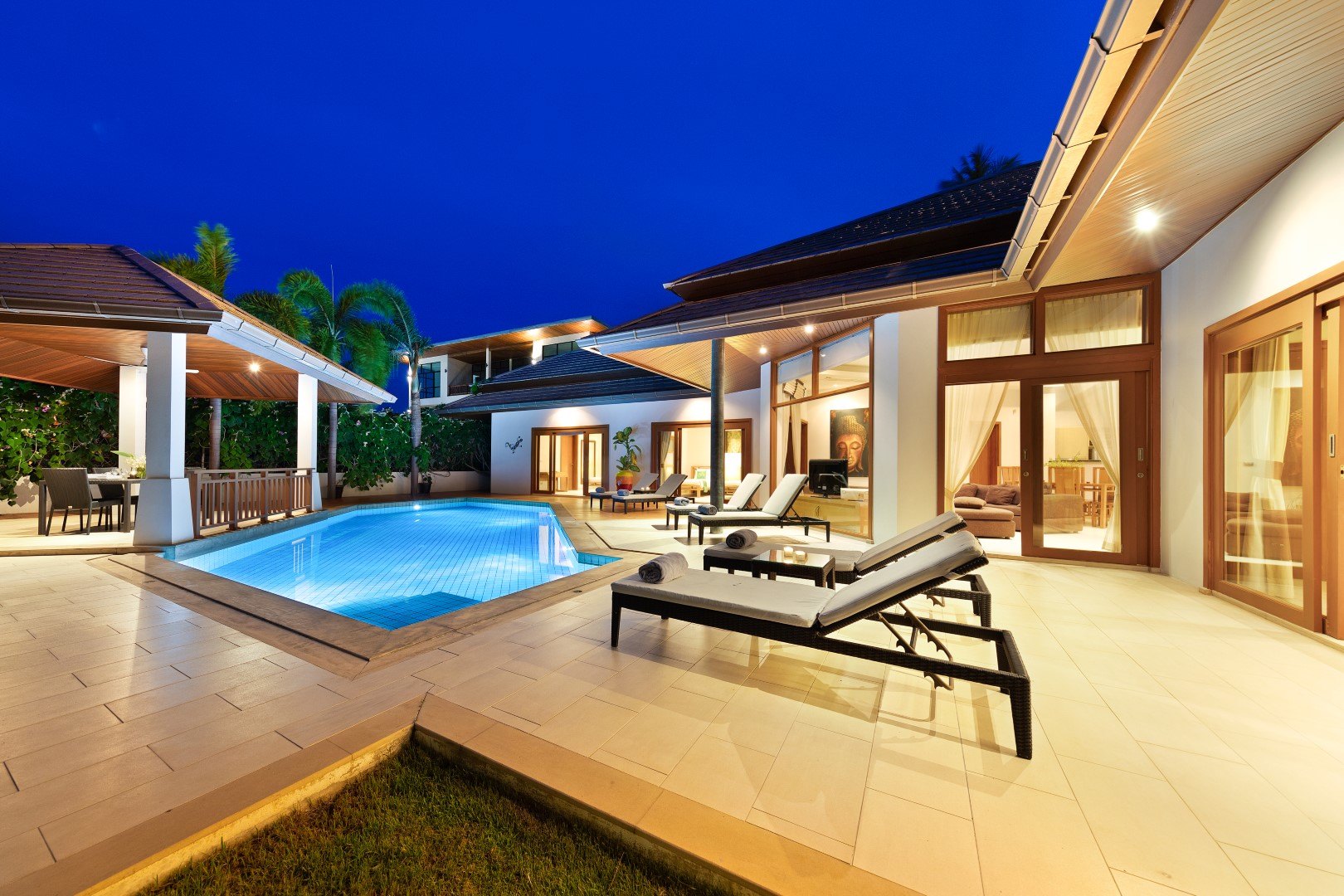 The pool from the far end, the house lit behind it