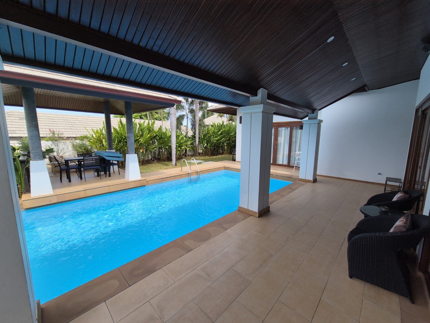 The covered terrace running beside the pool