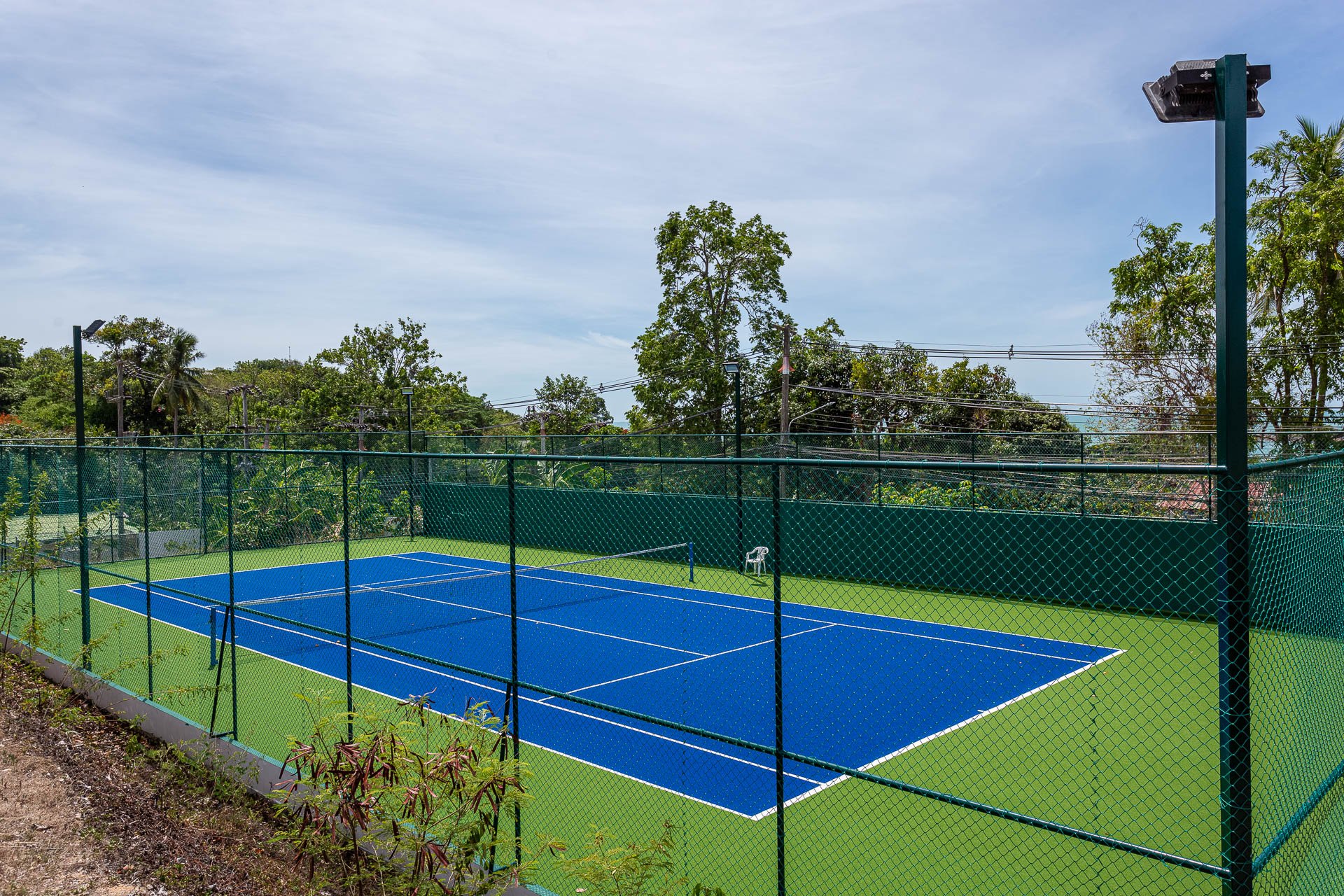 The floodlit tennis court inside the estate