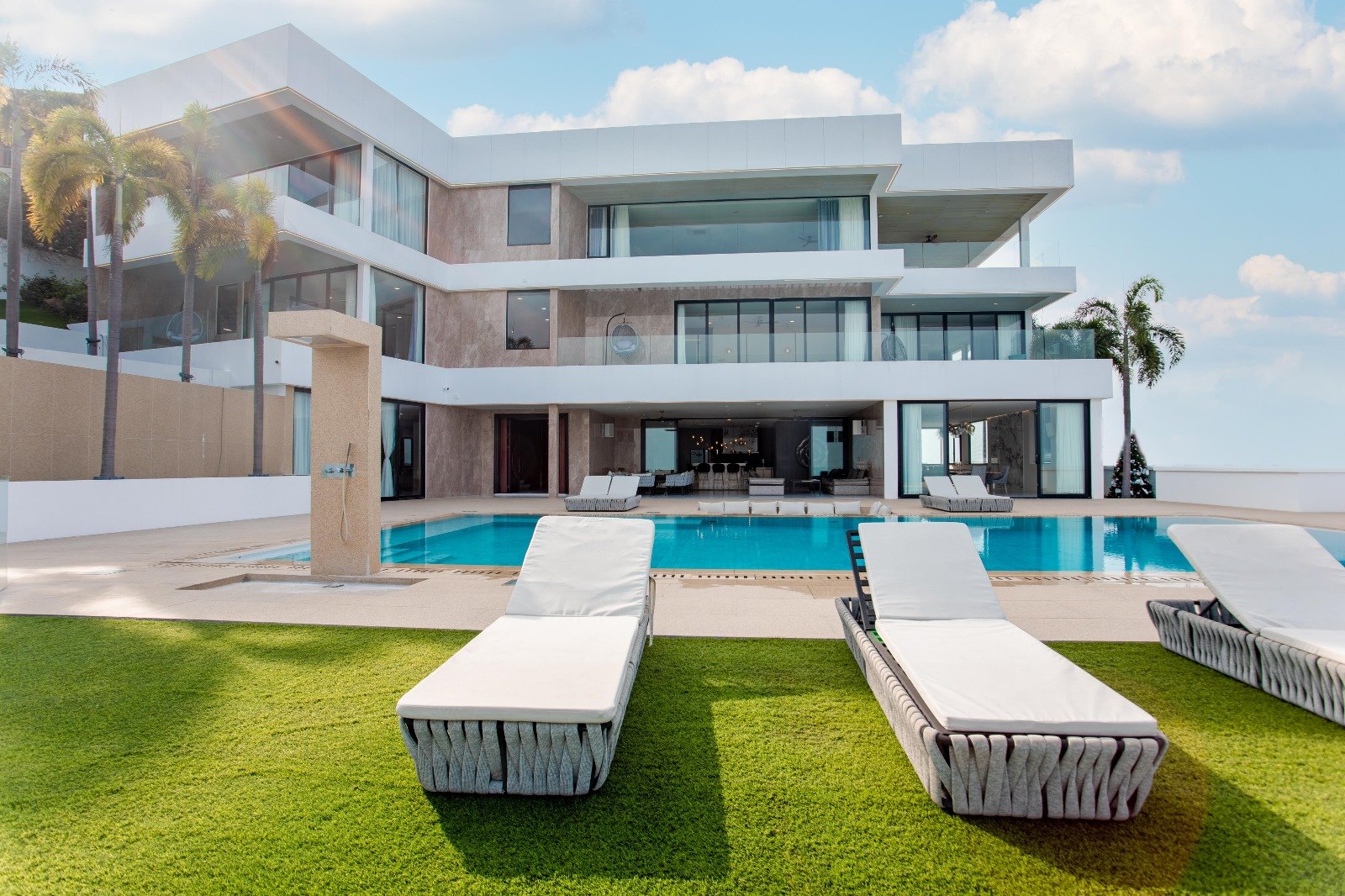 Sun loungers along the pool and the lawn behind