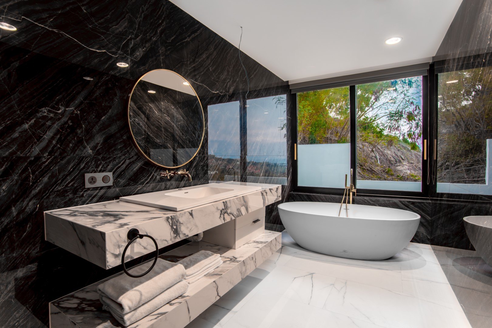 Black marble bathroom with a freestanding tub