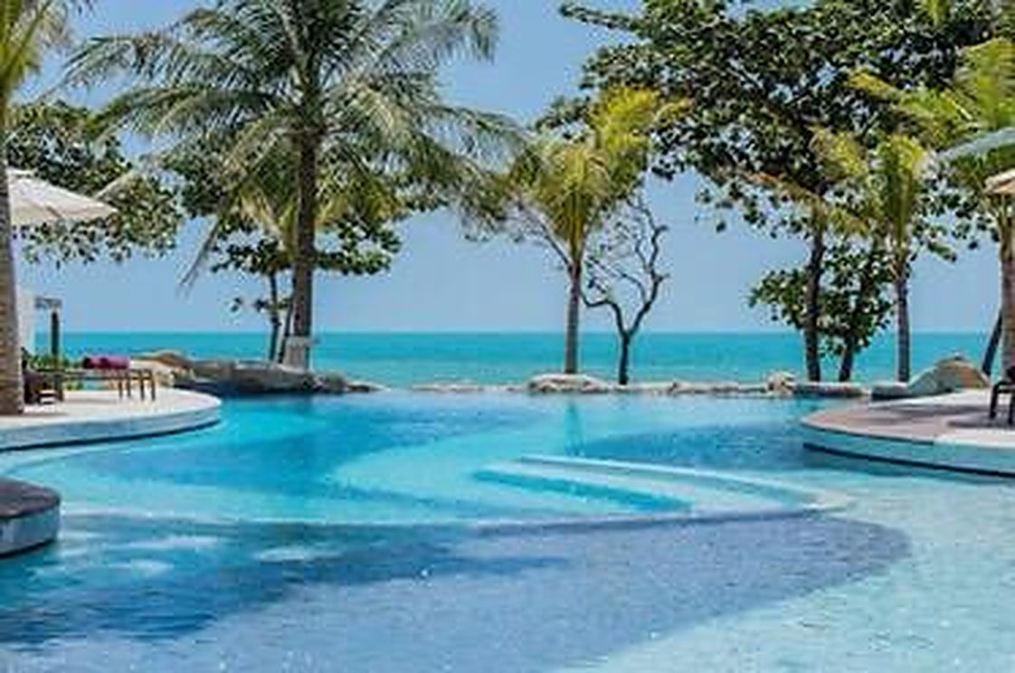 Pool and palms with the sea beyond