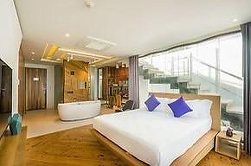 Suite with a freestanding bathtub beside the bed