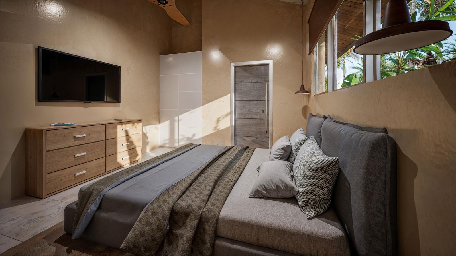 Second bedroom with natural textiles and wall-mounted TV