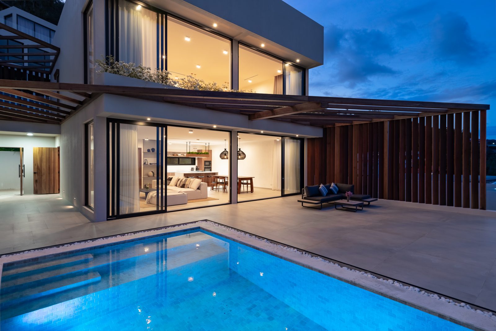 Pool terrace at dusk with the sea beyond