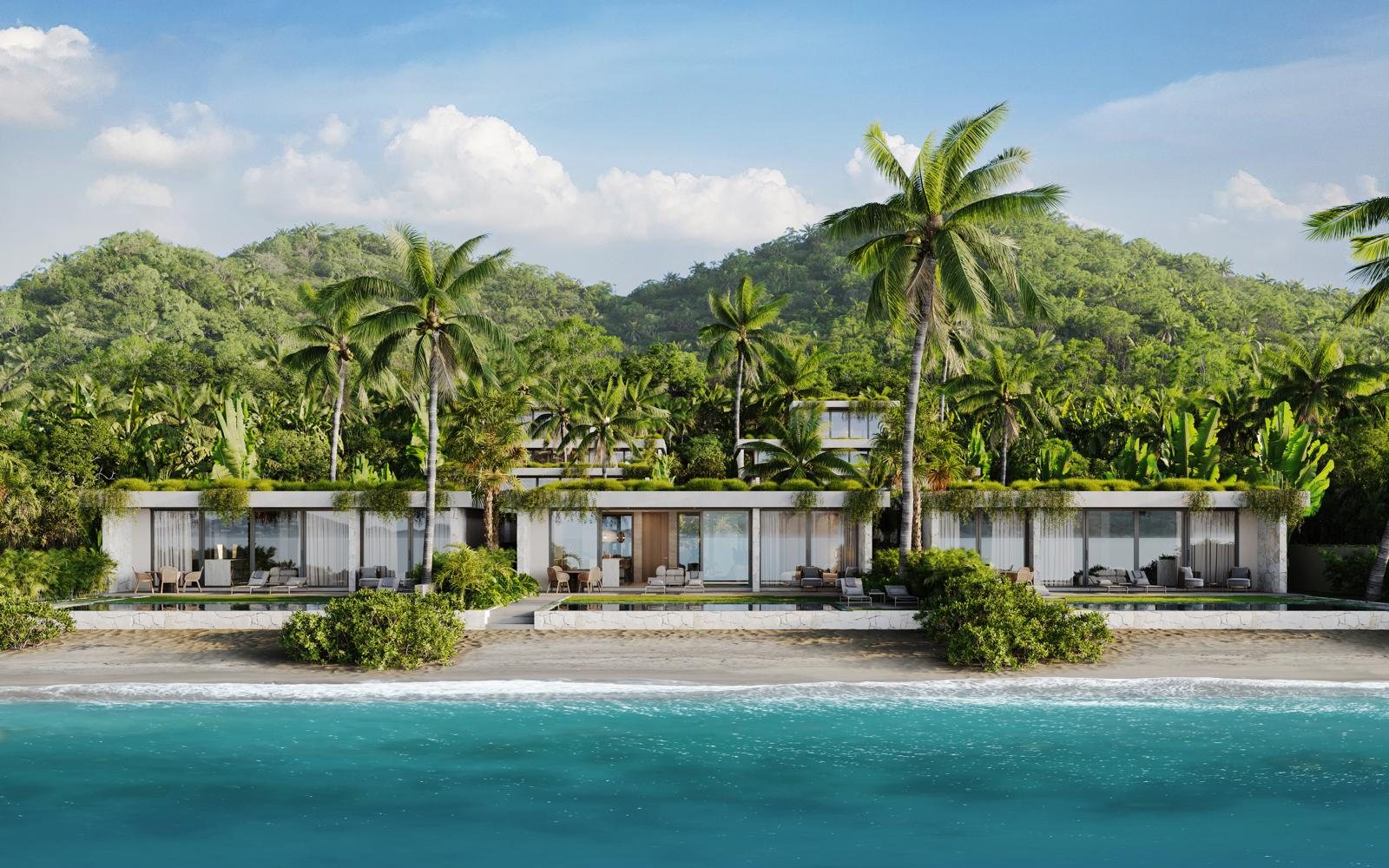 The front row of villas seen from the water, beach in front