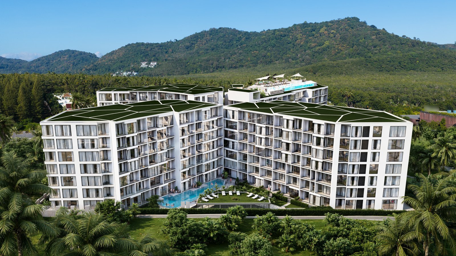 The four buildings with their planted roofs against the green hills of Rawai