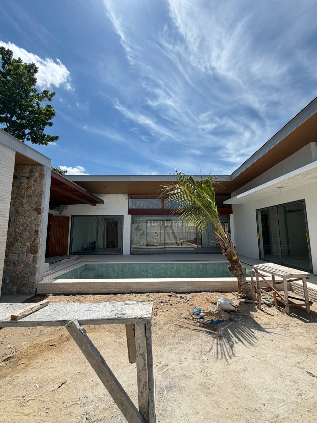 The house from the pool side, single storey with a wide roof overhang