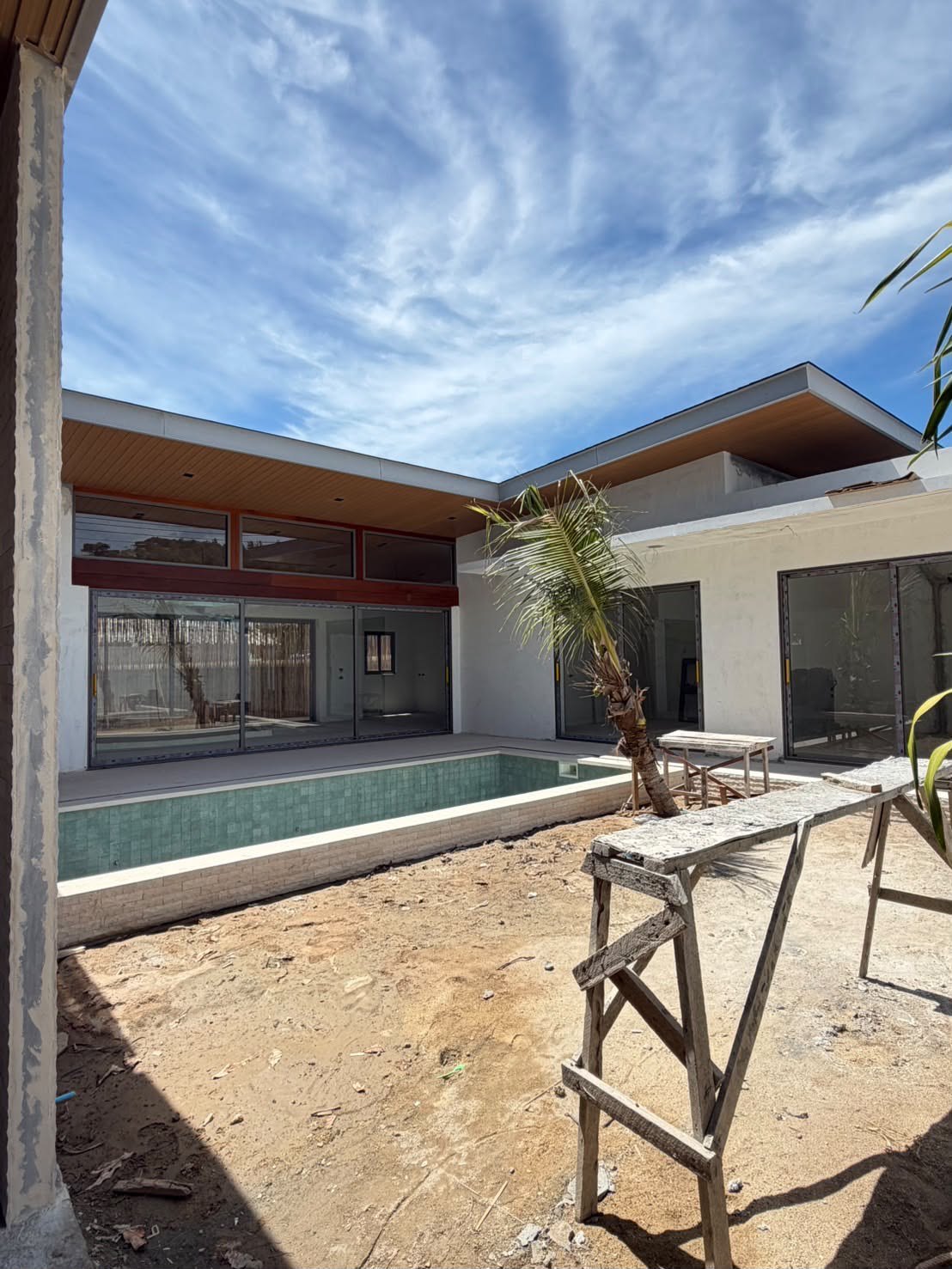 The house across the pool, glass doors along the whole wing