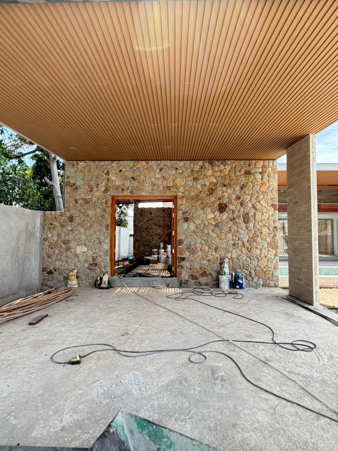 The stone-clad entrance and the timber ceiling of the porch