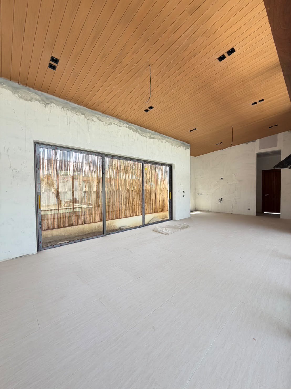 The living room shell with the high timber ceiling