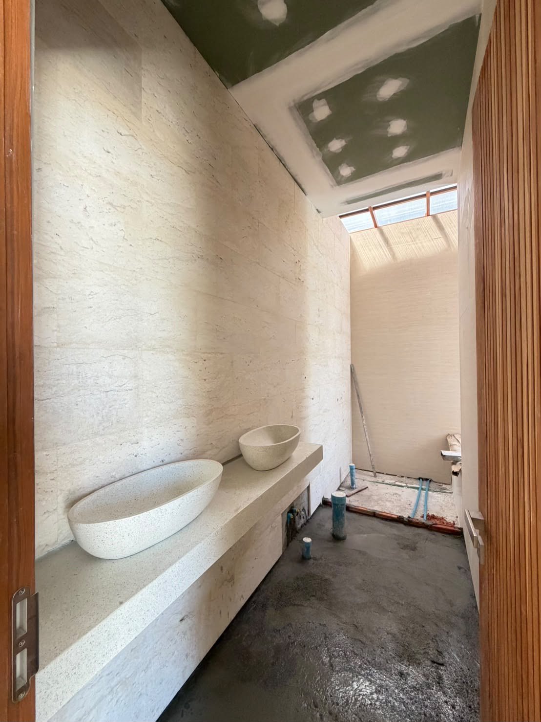 A bathroom in travertine, the basin counter in place